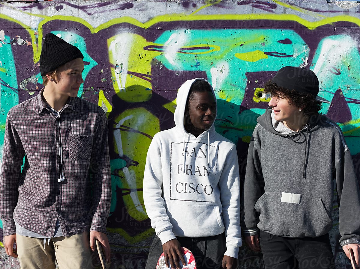 Friends with skates at graffiti wall