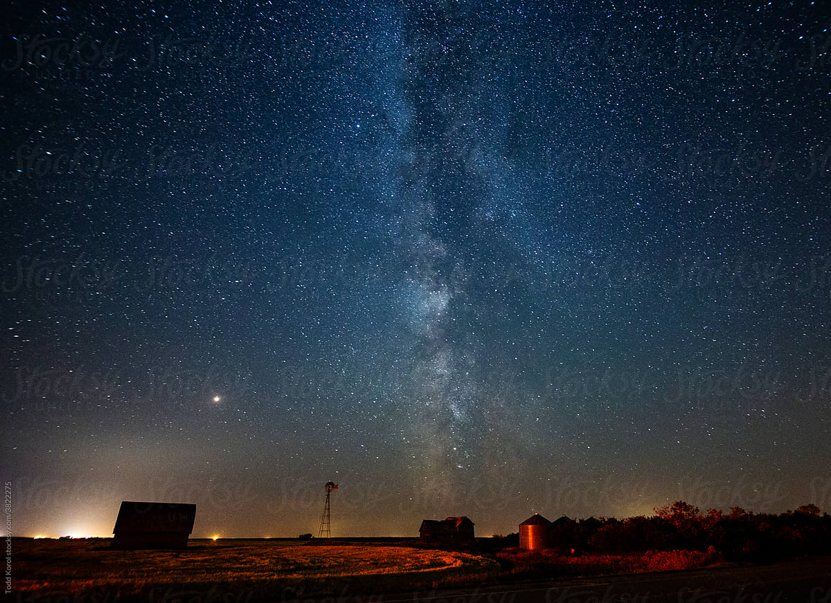 The milky way floats over an old farmyard on the prairies.