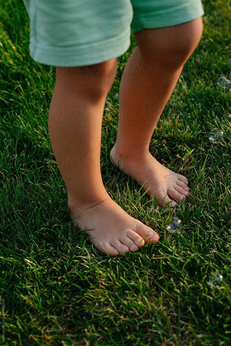 Child Standing In The  Grass