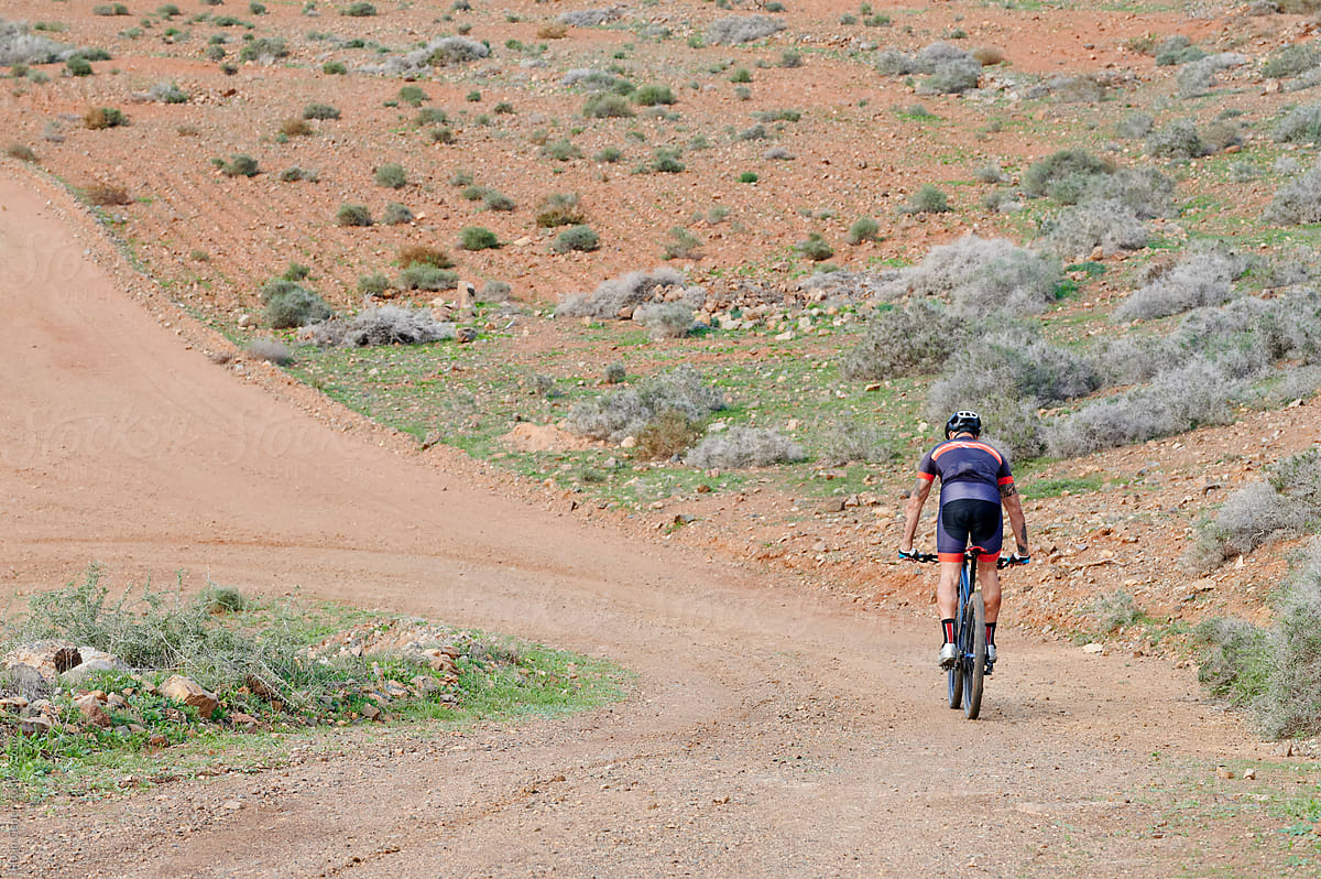 Man mountain biking on a dirt road