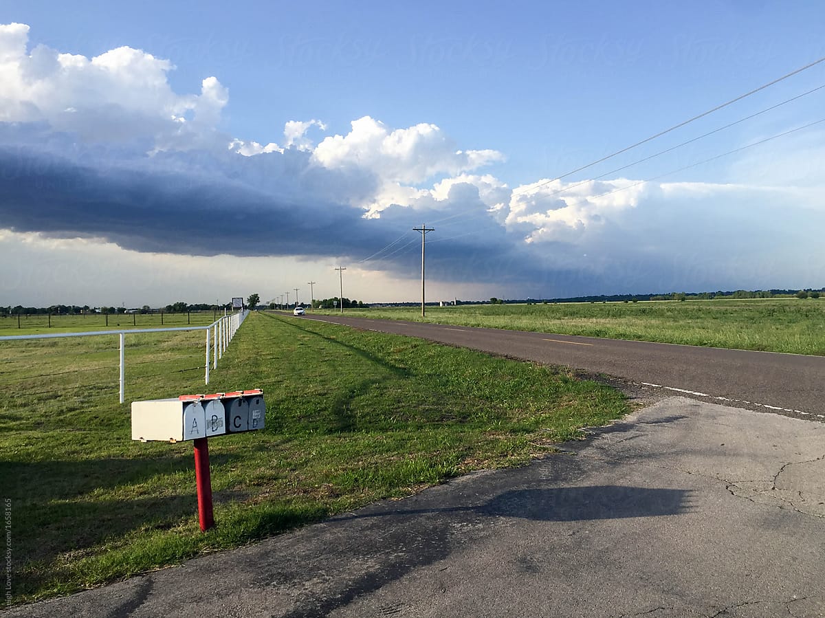 Oklahoma Storm Rolling In Along Country Road with Mailbox and White Fence.