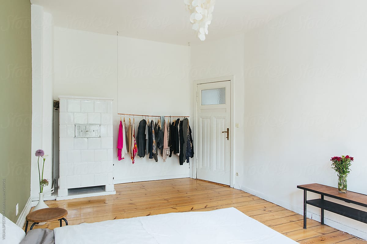 White Minimalist Bedroom With Female Clothes on Clothing Rail