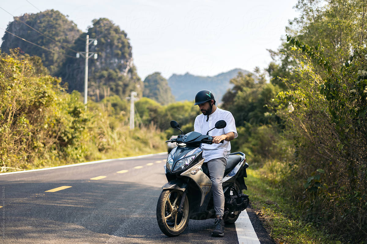 Traveler driving a motorbike in the countryside in Southeast Asia