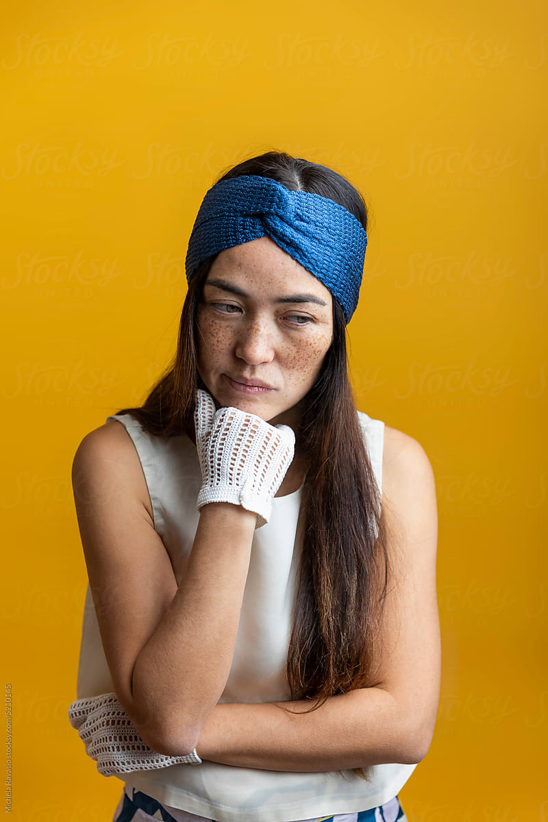 Thinking woman with headband and gloves