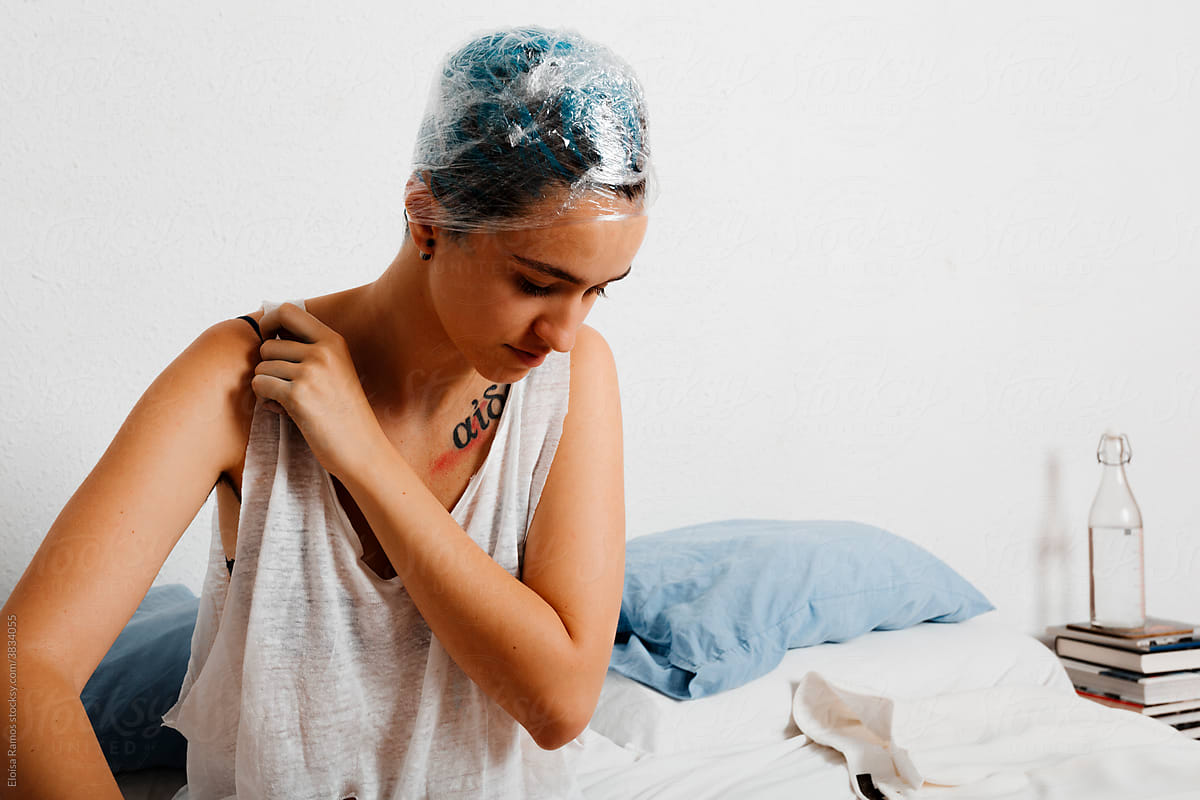 Androgyne model with blue dye relaxing at home