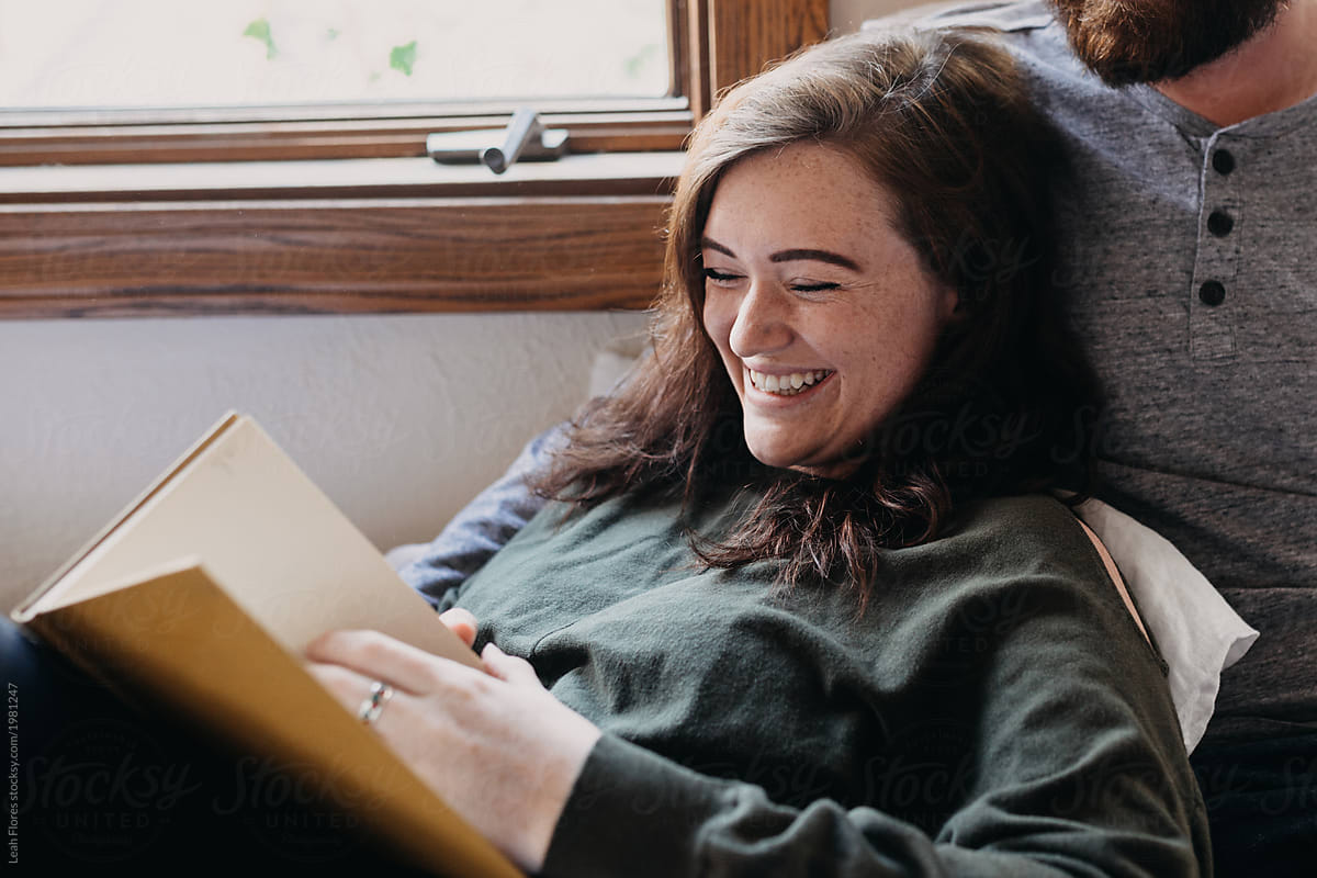 Woman Laughing And Reading Book