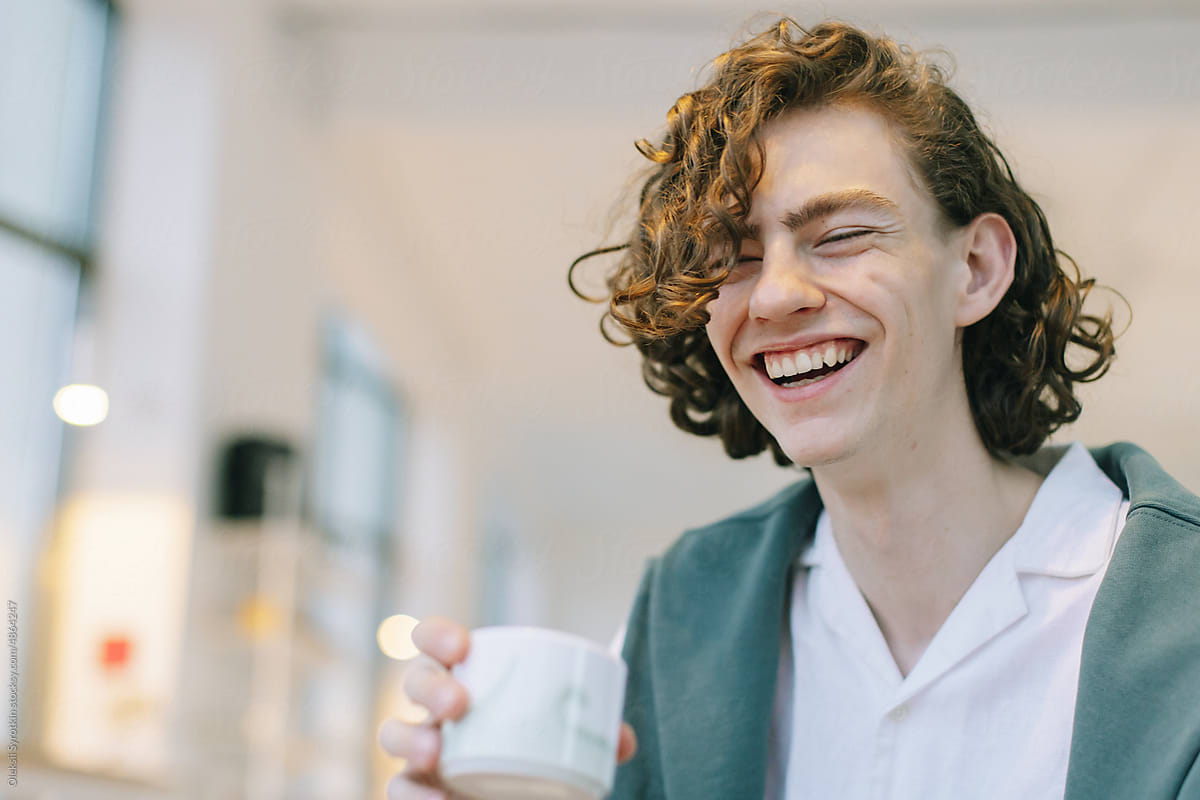 Young Man Laughing with Drink in Hand
