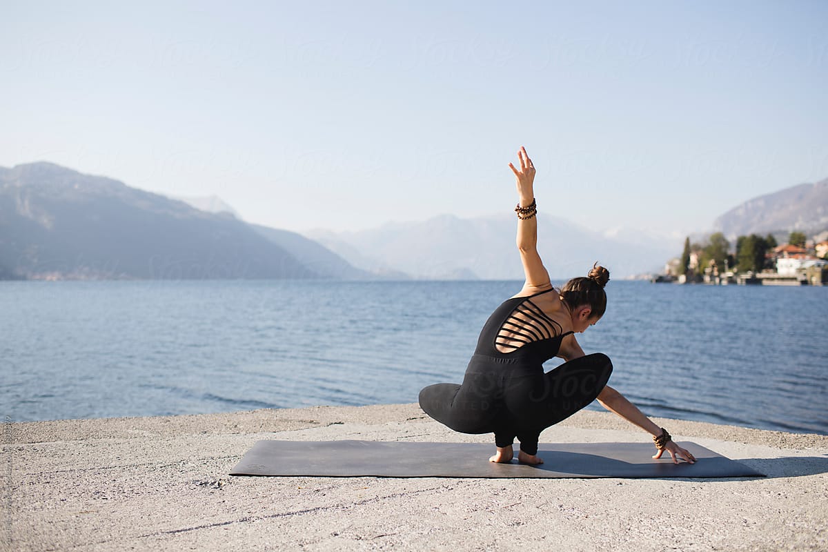 Doing Yoga Practice By The Lake Del Colaborador De Stocksy Michela Ravasio Stocksy