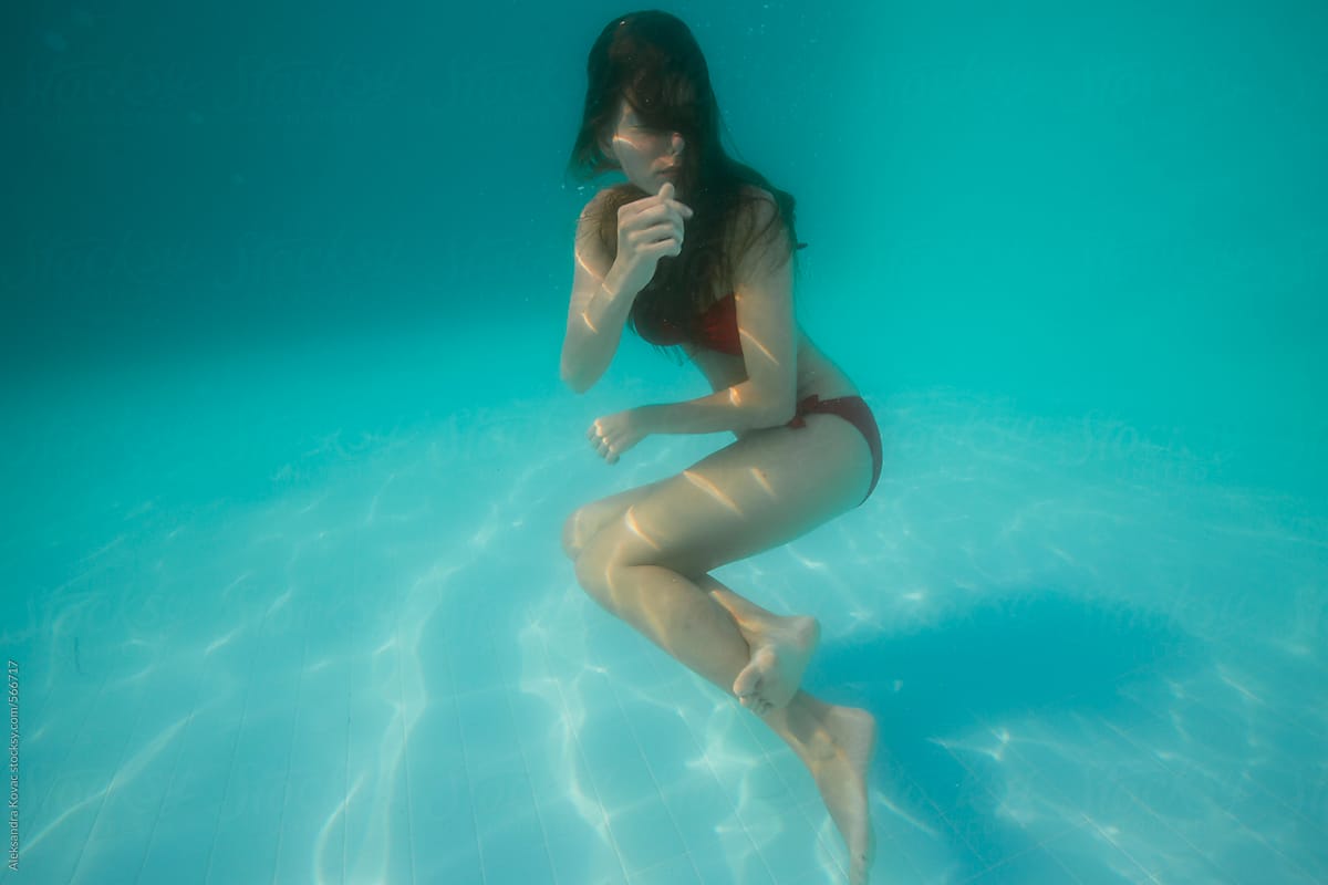 Woman float underwater in swimming pool.