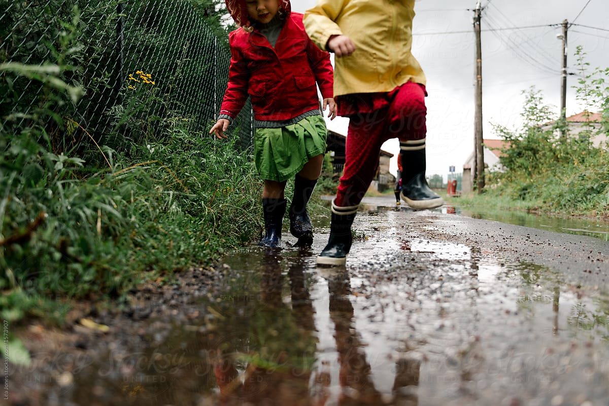 two girls playing in the street after the rain