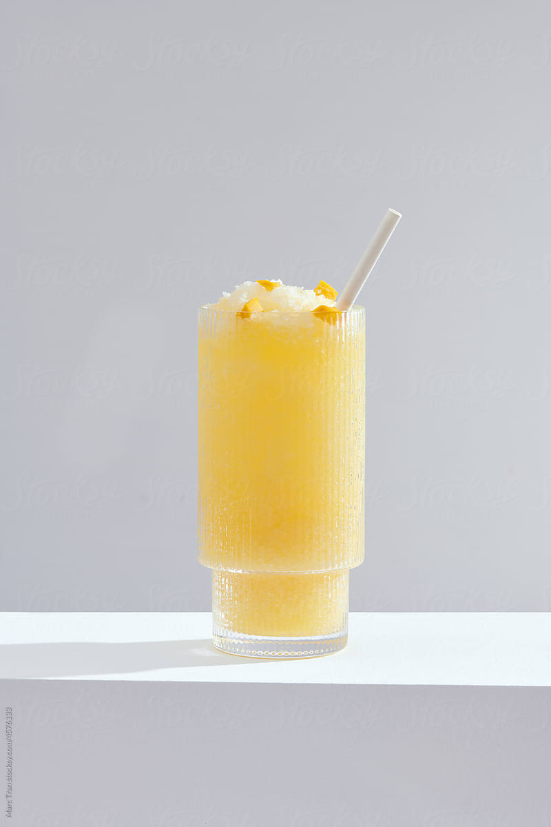 Peach smoothie in a tall glass with slice fruit isolated standing