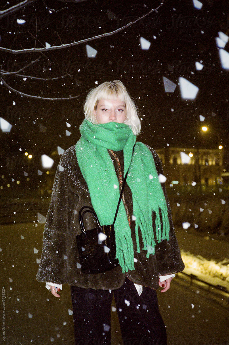 Z generation blond girl in the snow during a snowstorm winter night