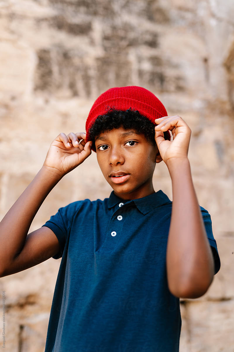 Young man putting on hat
