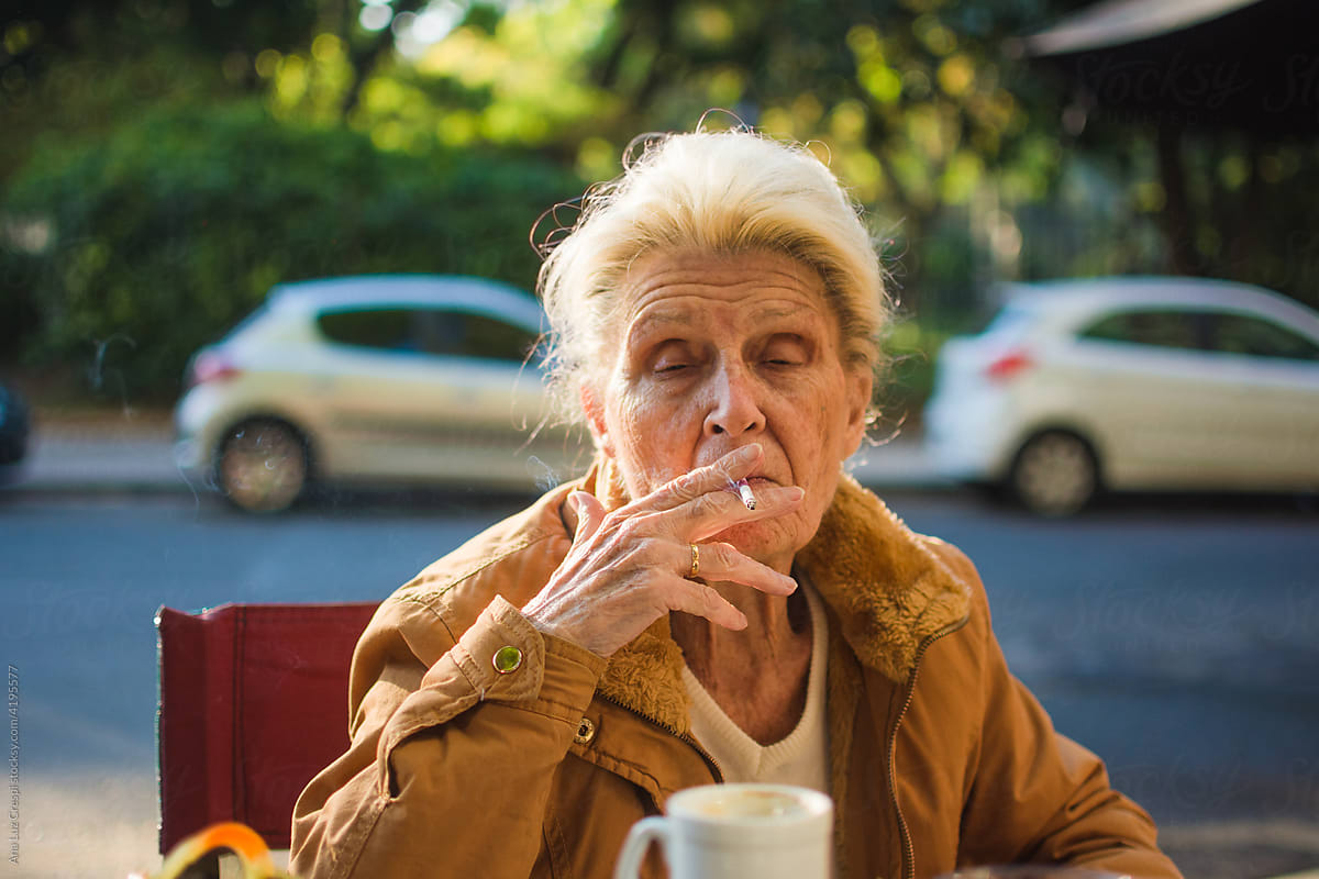 White hair lady smoking a tobacco cigarette