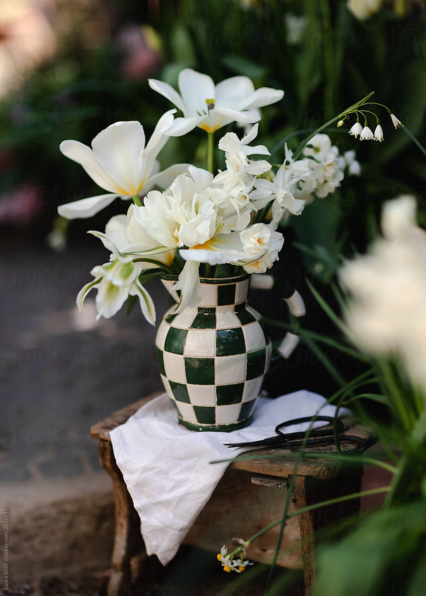 Arranging flowers in porcelain pitcher