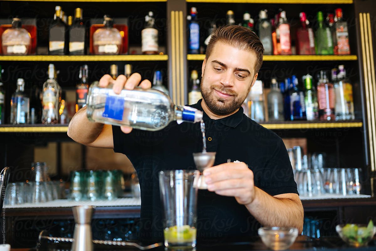 Barkeeper adding vodka to cocktail