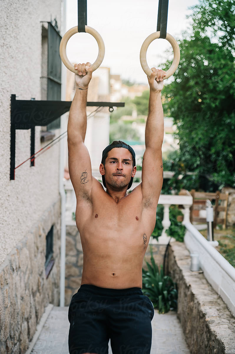 Strong man exercising with gymnastic rings