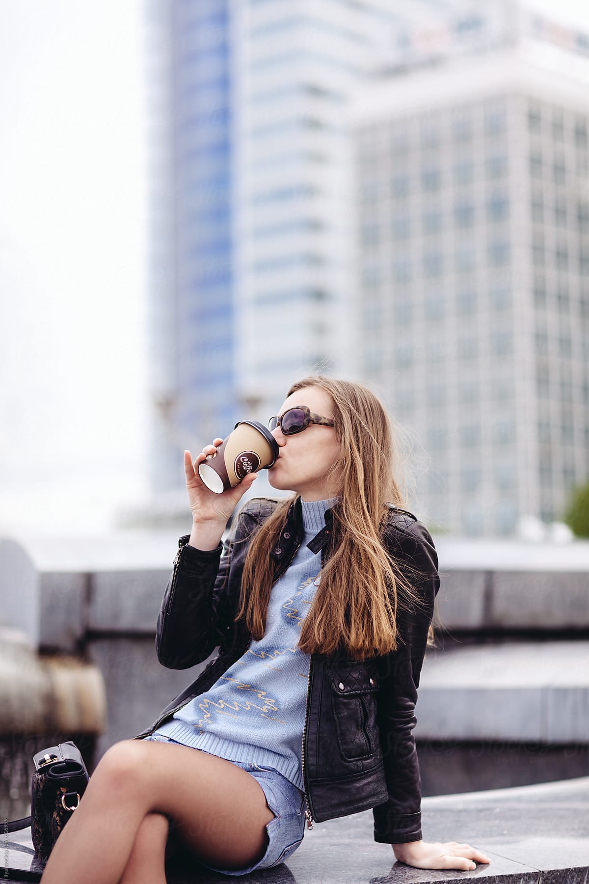 Young woman drinking coffee in the city