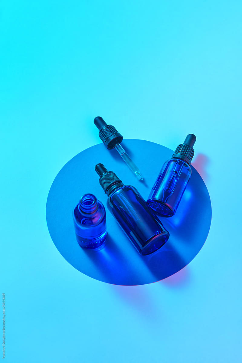 Glass blue bottles with cbd oil on a round card.