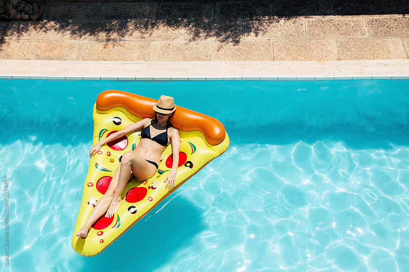 Woman on a pizza float in a swimming pool