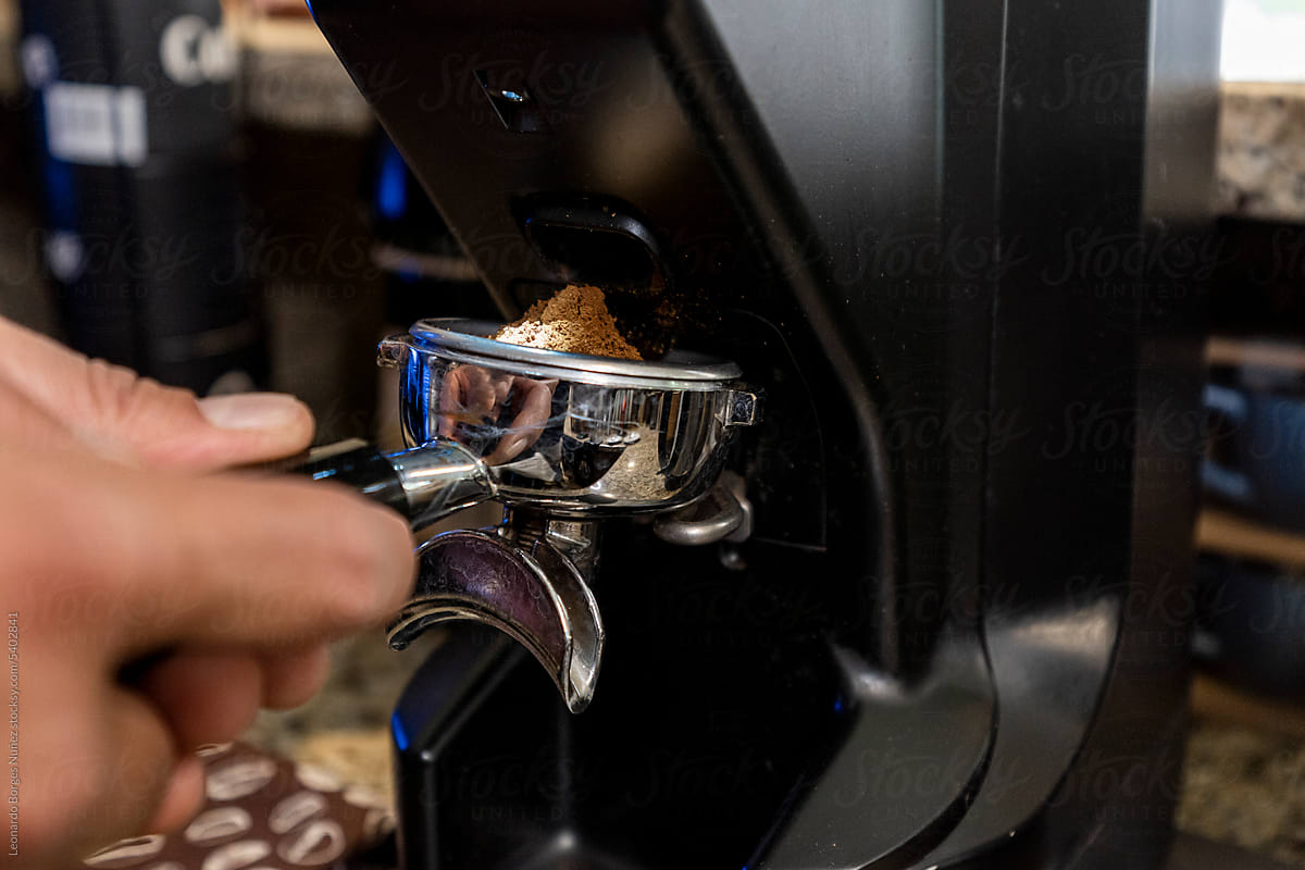 Person Making Coffee Holding a Filter Holder