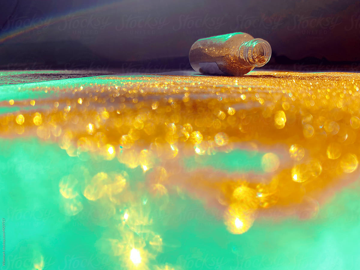 The golden sheen of spilled glitter on blurred background.