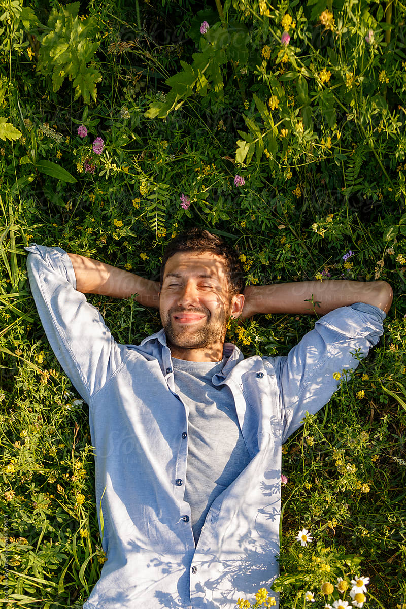 Delighted man relaxing in grassy field
