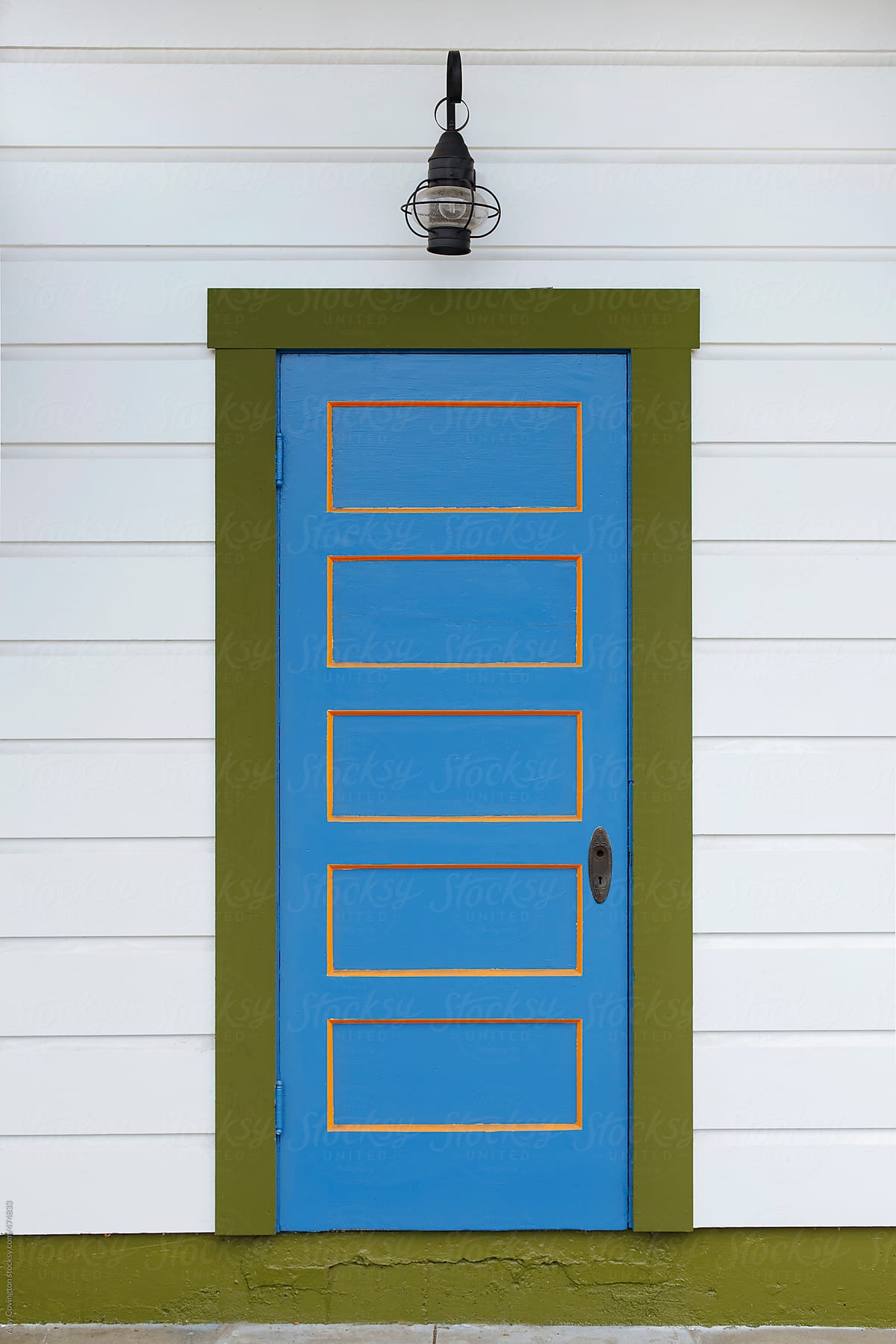 Old blue and orange wooden door with olive green trim
