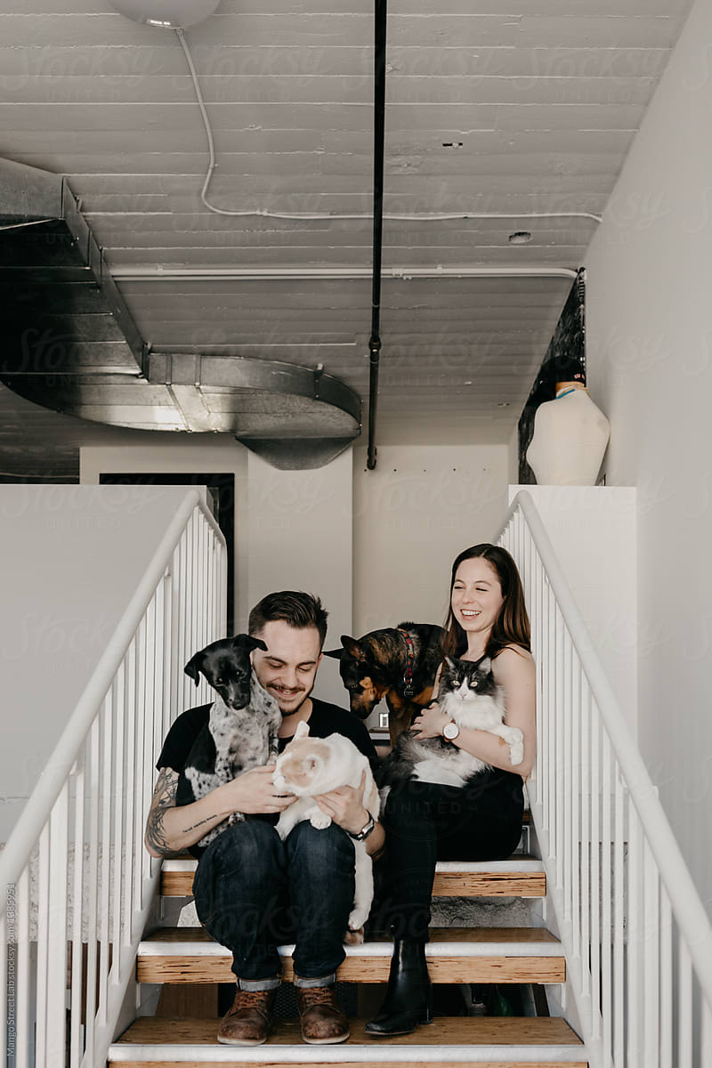 Young Couple with Pet Cats and Dogs
