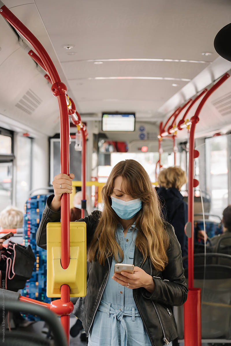 Woman inside of Bus Wearing Surgical Mask