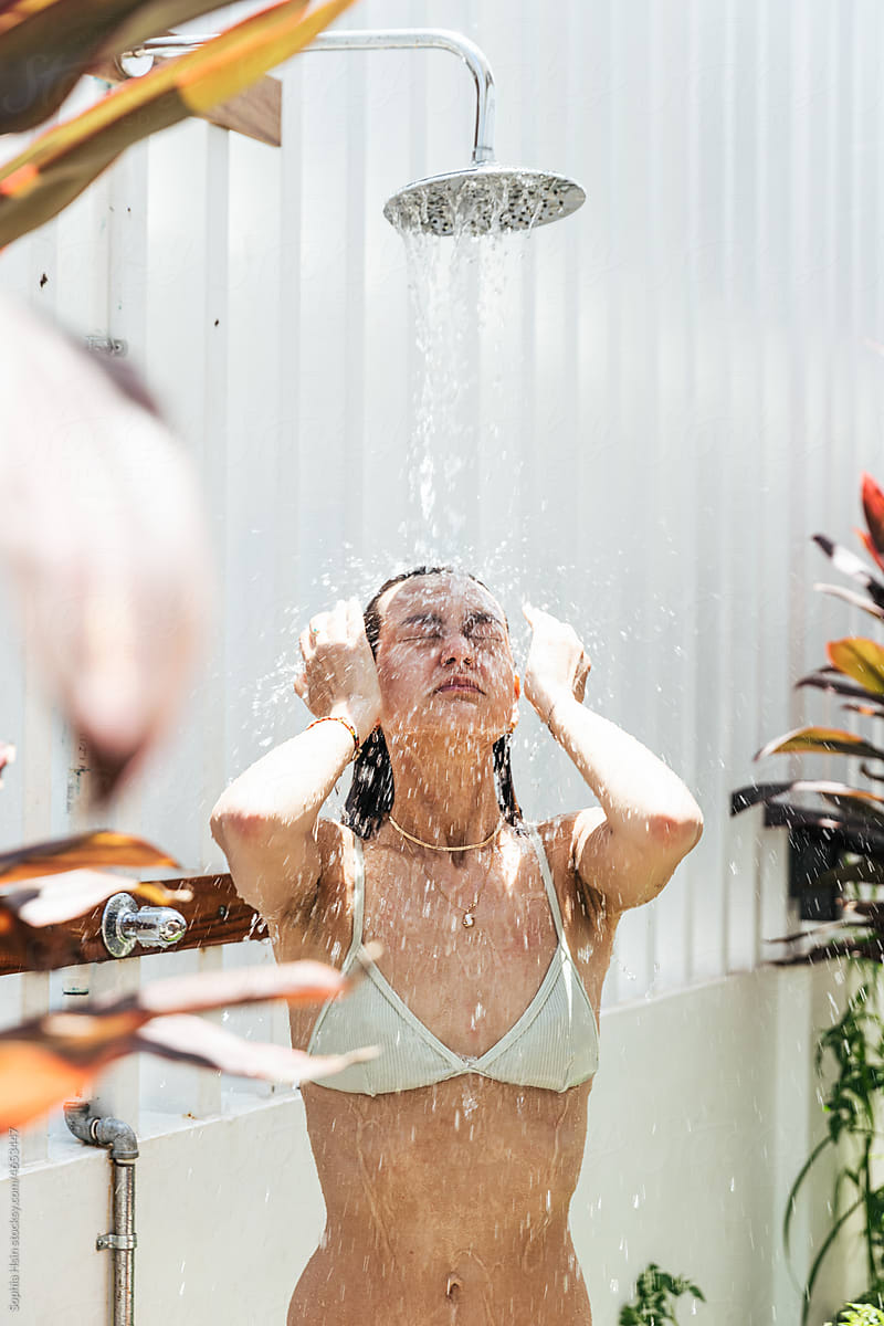 Woman washing her face at outdoor shower