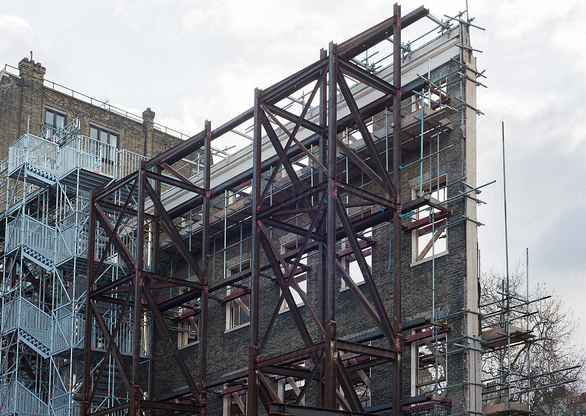 restoration facade of old house, red steel structure forms to avoid collapsing