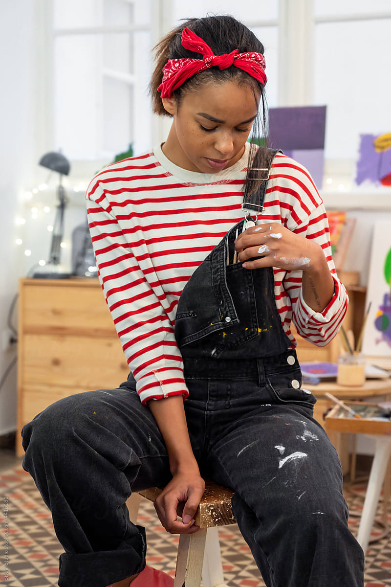 Black artist in overalls in workshop