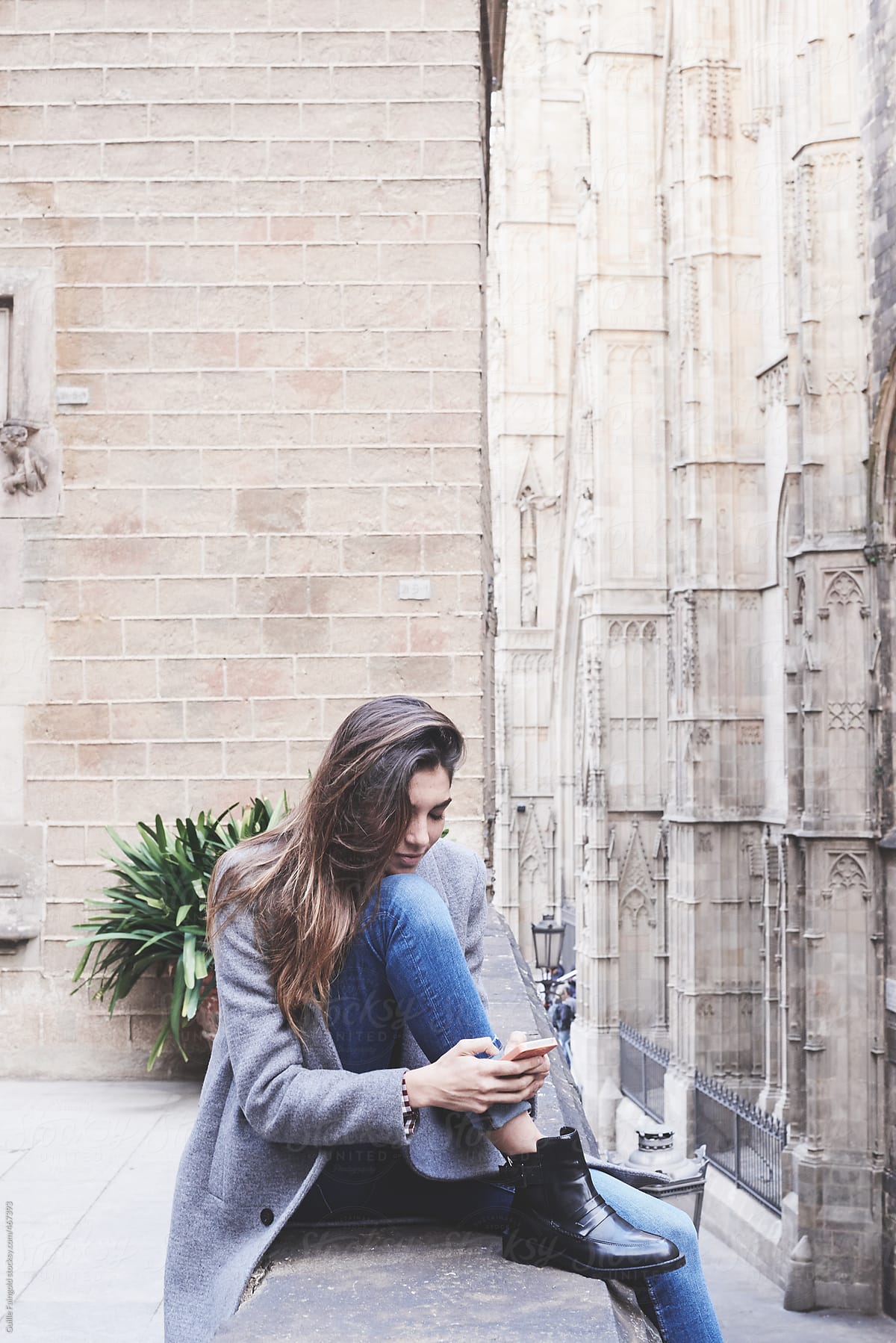 Young woman using smartphone outside old building