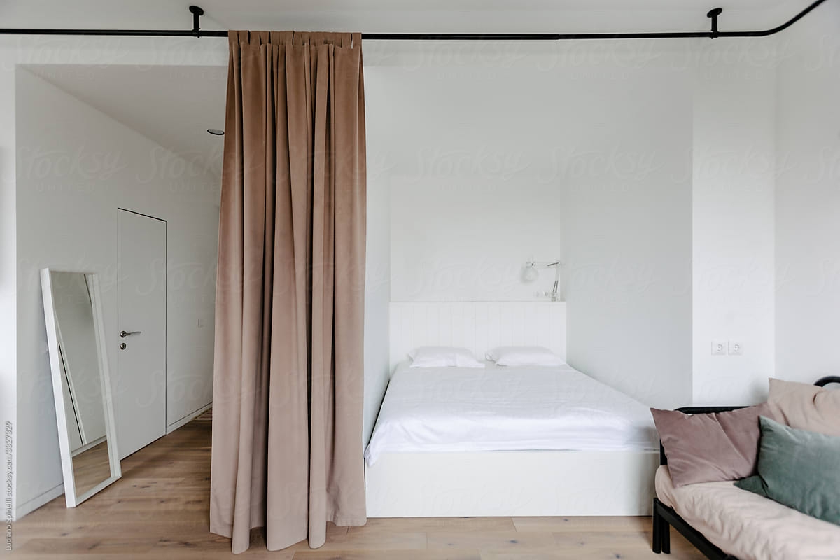 Bed room in a small flat with a velvet brown curtain