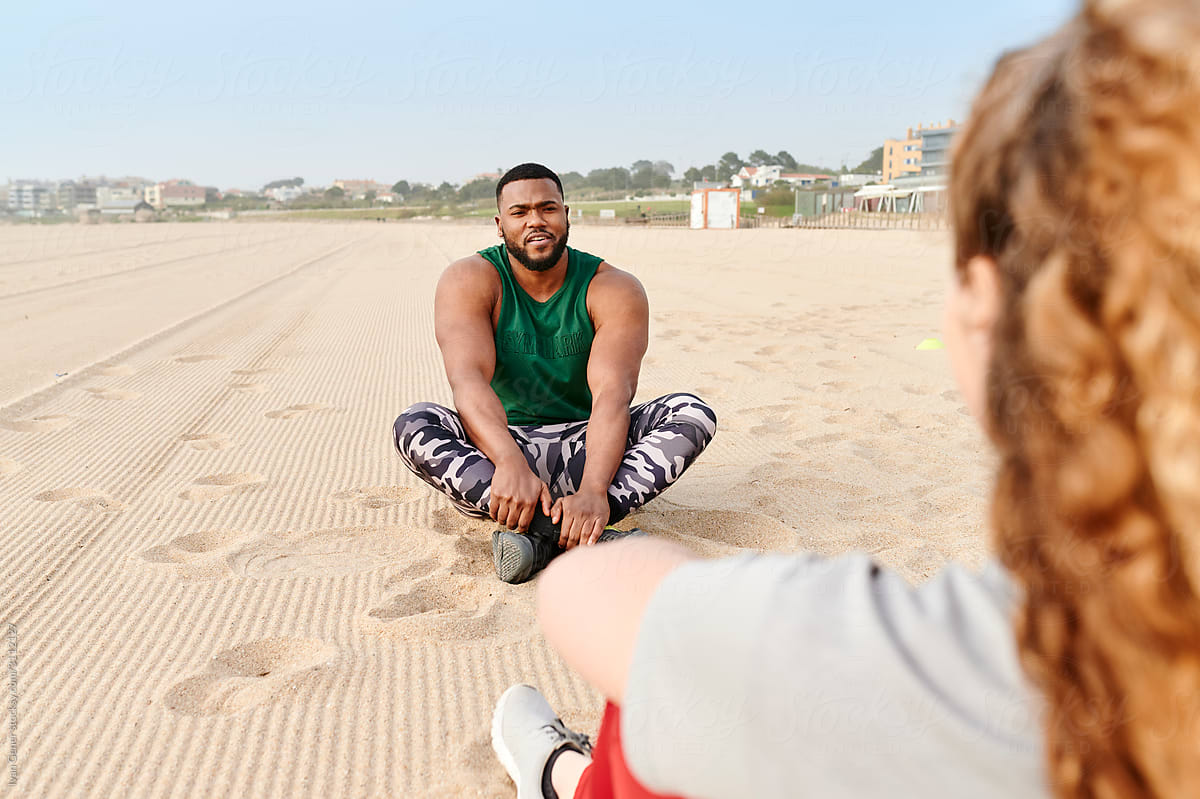 Man talking with a friend after a beach workout