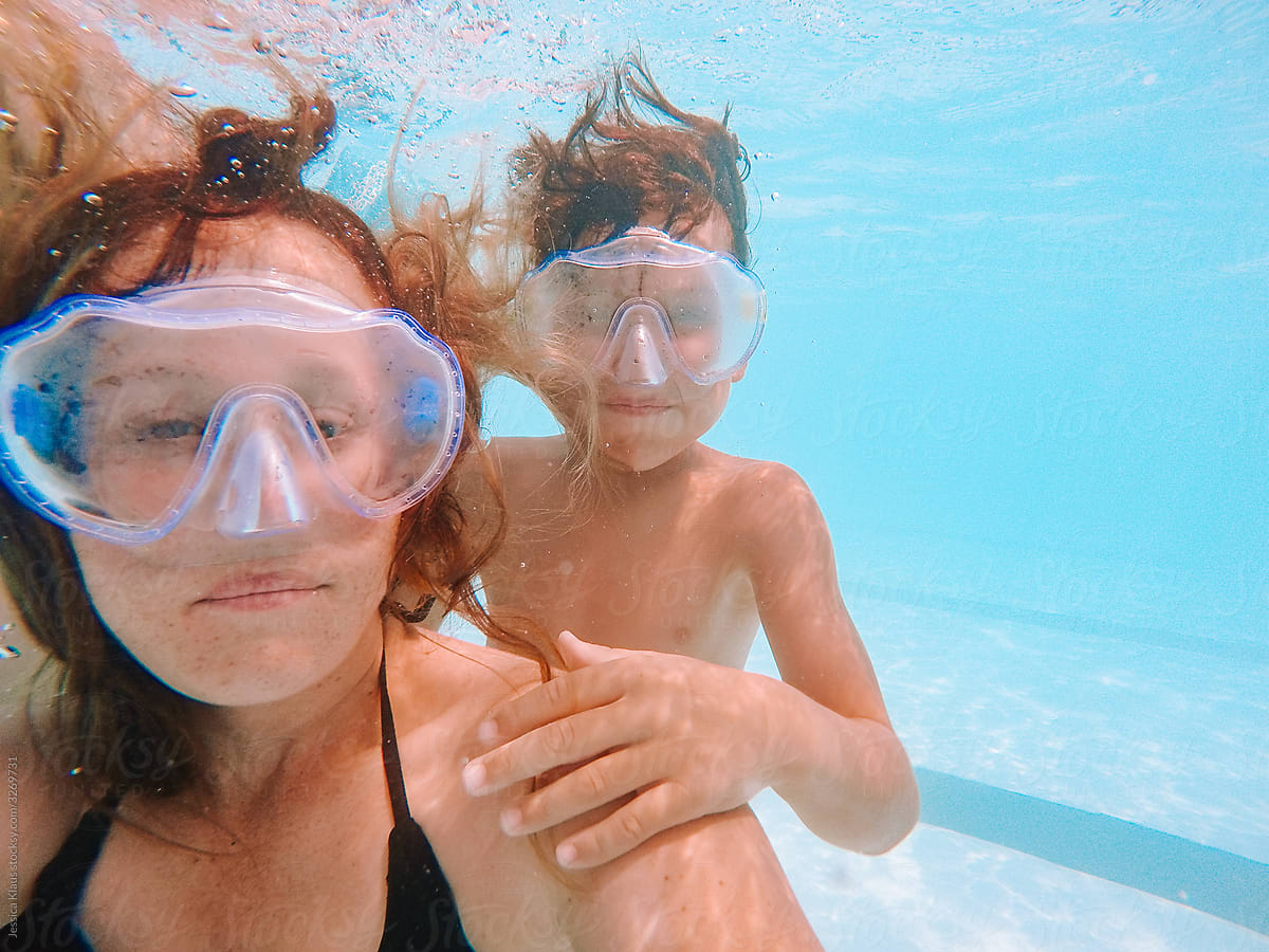 Mother taking self-portrait with son underwater.