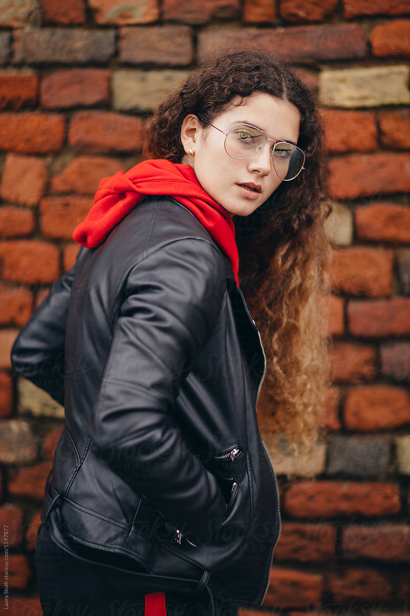Young woman wearing black leather motorbike jacket and red hoodie