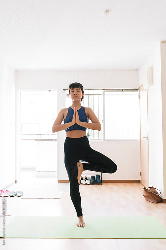 Young Asian woman doing yoga in her apartment in Japan