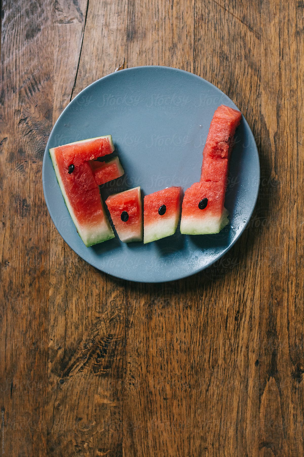 food,  watermelon letters  in a blue plate on a wooden table