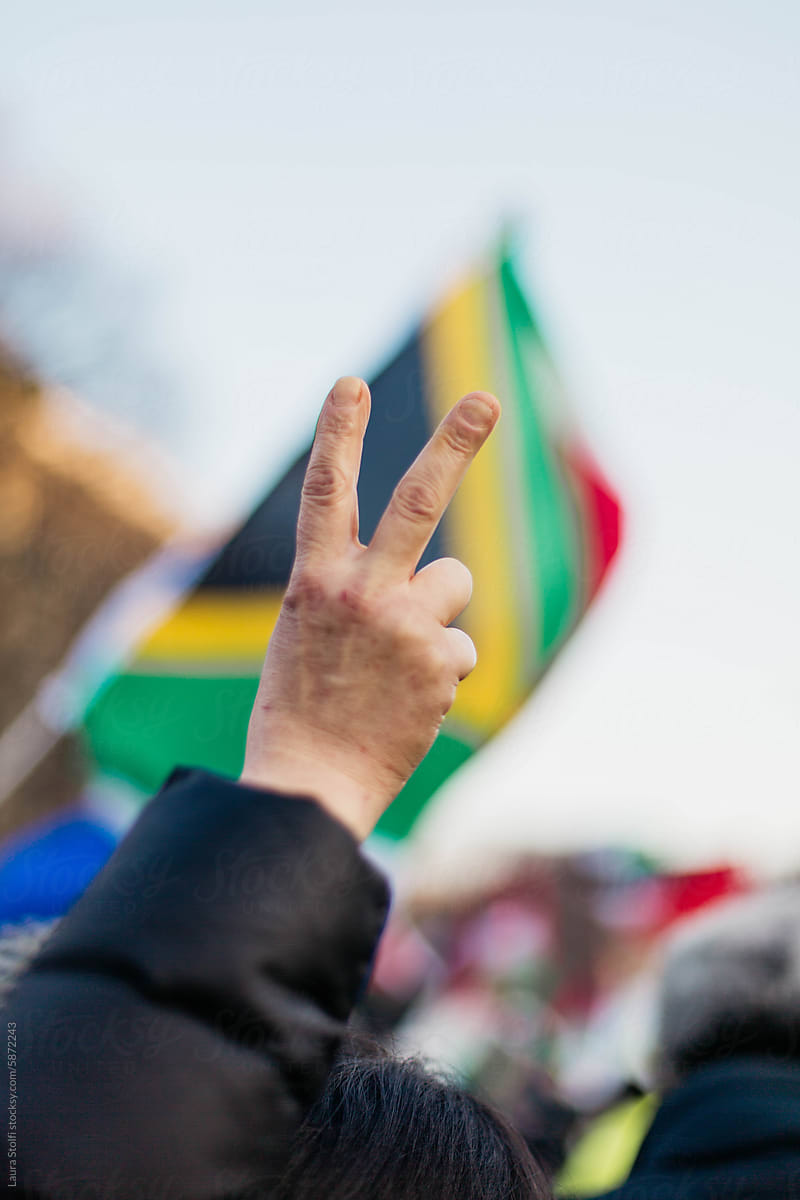 Victory sign against South Africa flag at a protest
