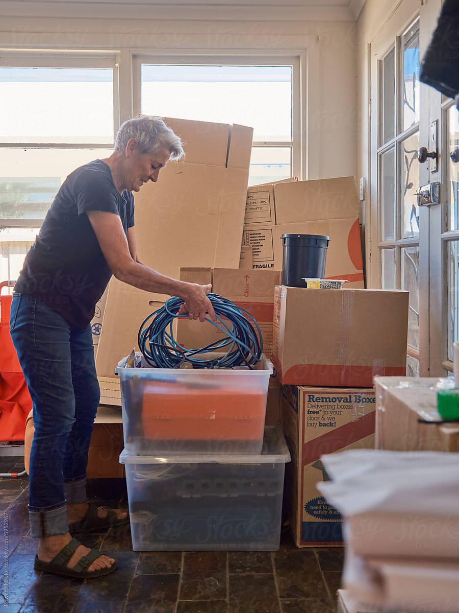Woman packing cables into box during house move