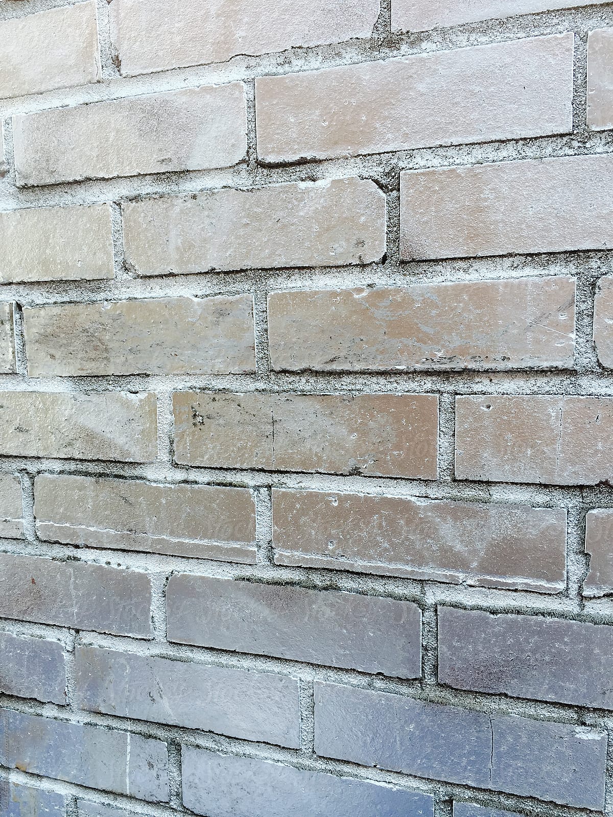 Silver paint covering graffiti tags on brick wall, close up