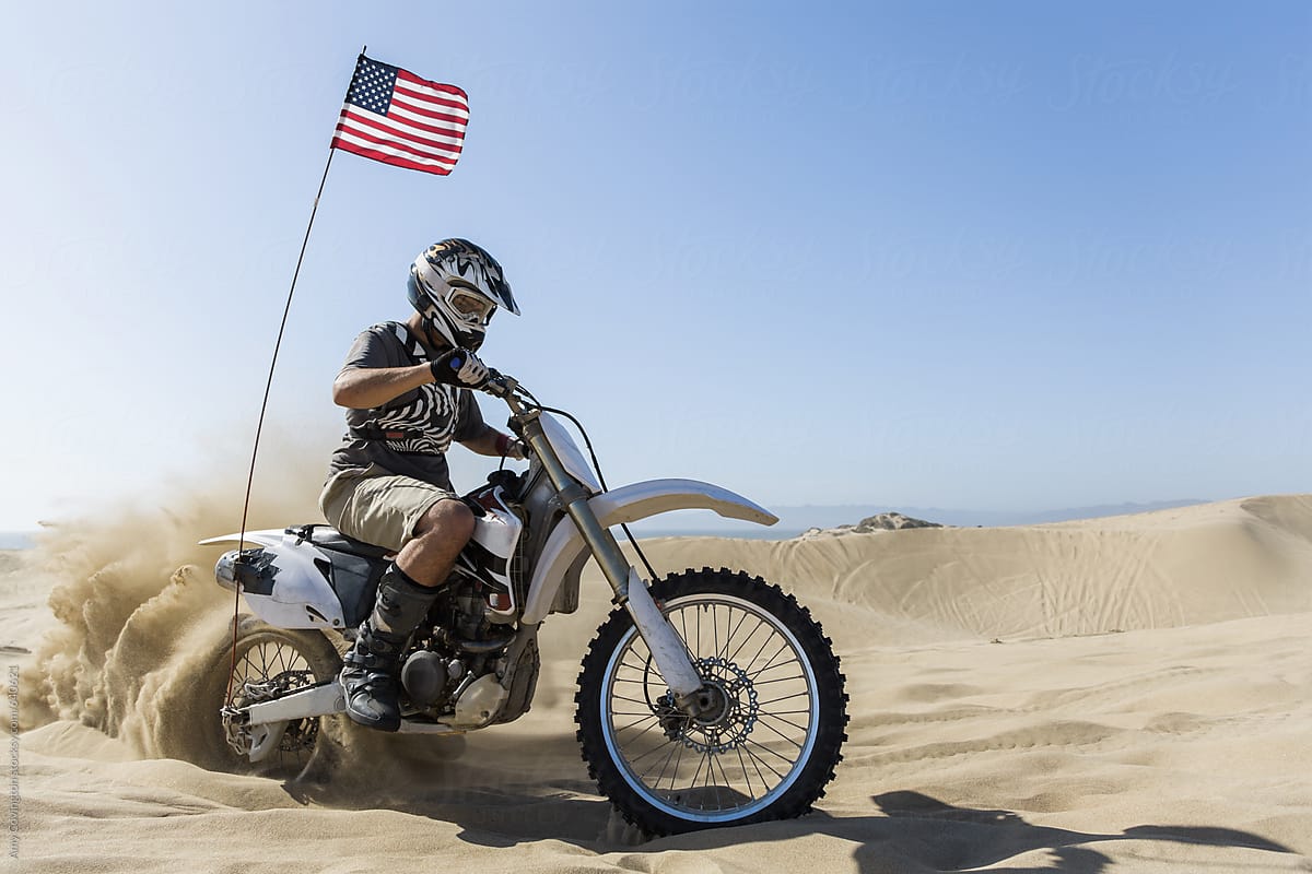 Young man on a motorcycle with an American flag
