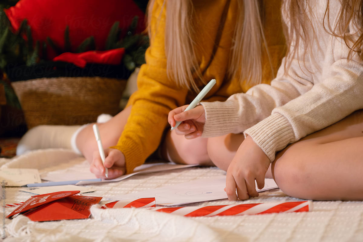 Crop girls writing letters to Santa during Christmas