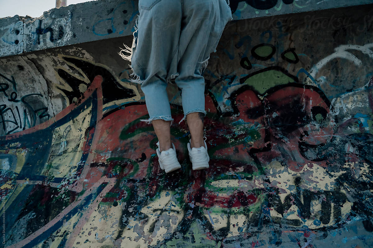 Young woman climbing graffity wall