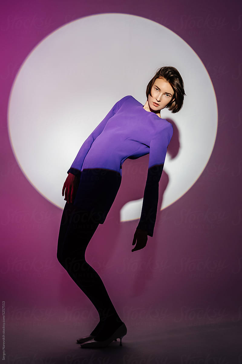 Female model in purple dress leaning back