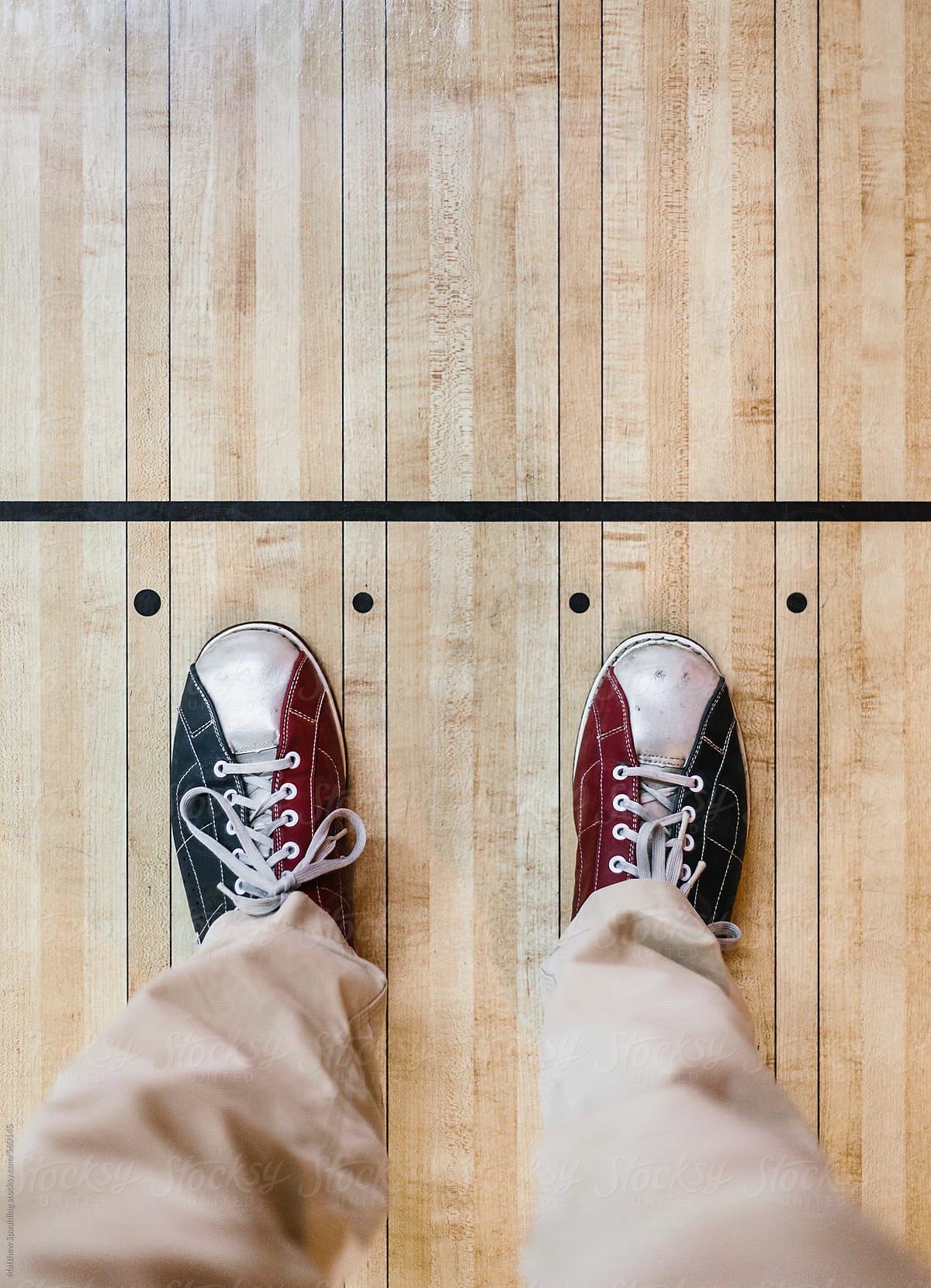 View of bowling shoes on wood floor at alley