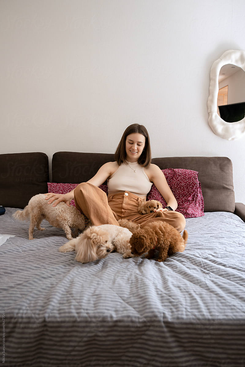 woman playing with her cute dogs in apartment