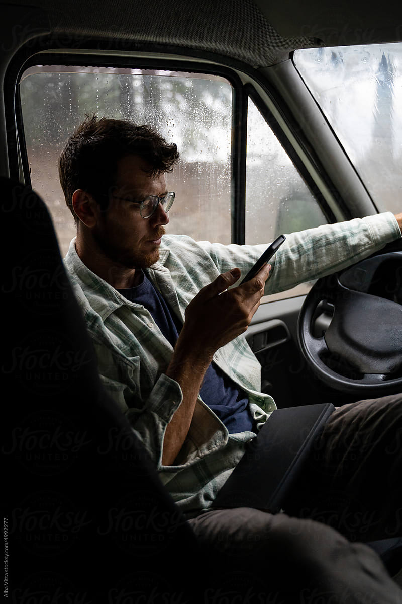 Man using phone inside car